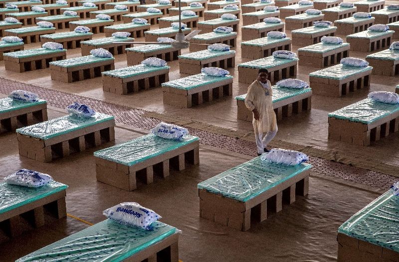 A volunteer walks past disposable beds made out of cardboard at the campus of Radha Soami Satsang Beas, a spiritual organization, where a coronavirus disease (COVID-19) care centre has been constructed for the patients amidst the spread of the disease, in New Delhi. REUTERS/Danish Siddiqui